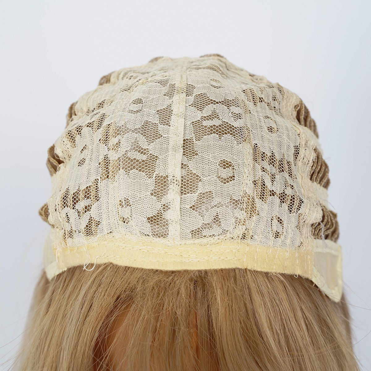 Warm-toned blonde wig cap with beige lace panel and adjustable straps
