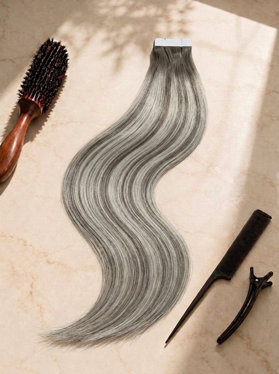 Straight tape-in extensions, long smooth waves, smoky silver gray, tape tab at top.
