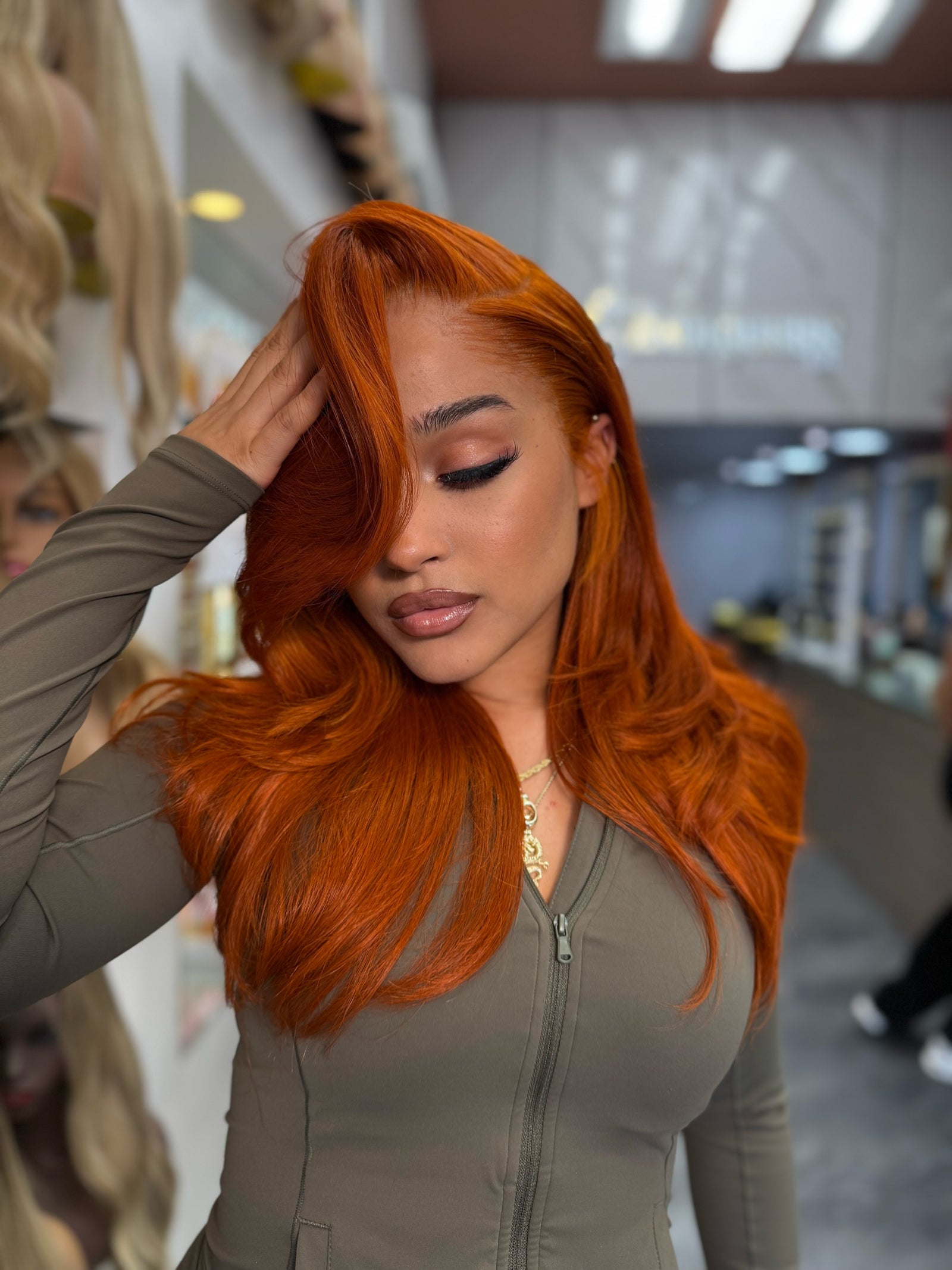 Long wavy ginger-orange lace wig with side part, full volume around crown