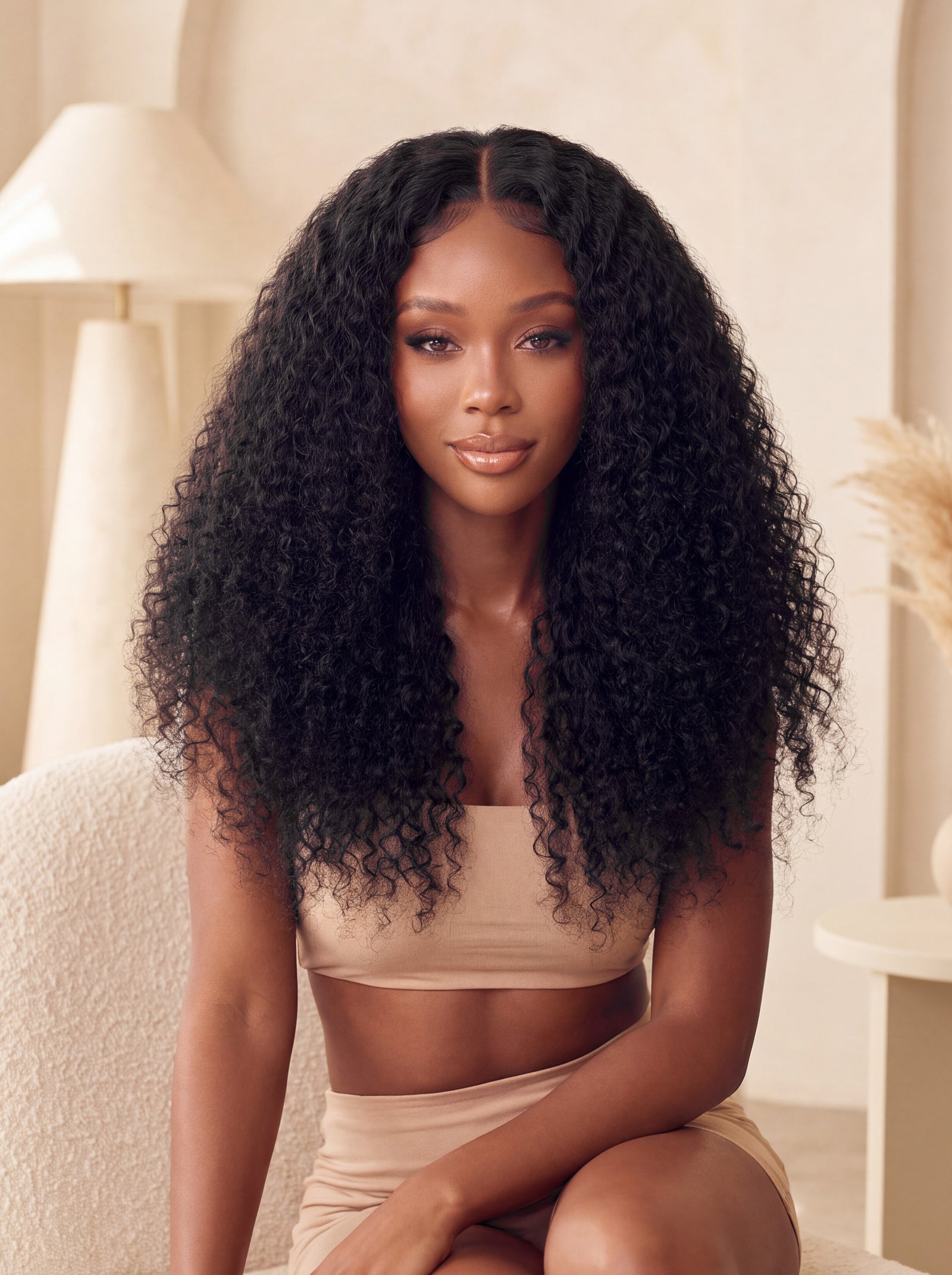 Curly U-part wig with long black curly ringlets and U-part center part on model