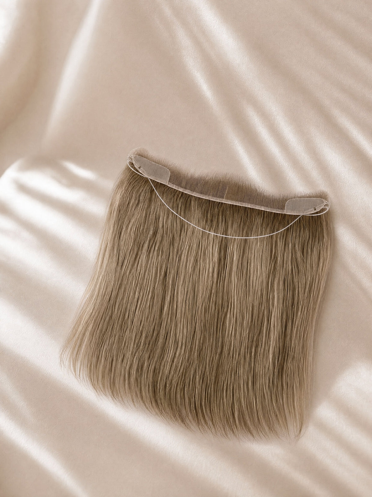 Hair line topper with lace base and long, straight blonde-brown hair strands.