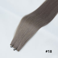 Tape-in hair extensions, straight strands in ash brown #18 with visible tape clips