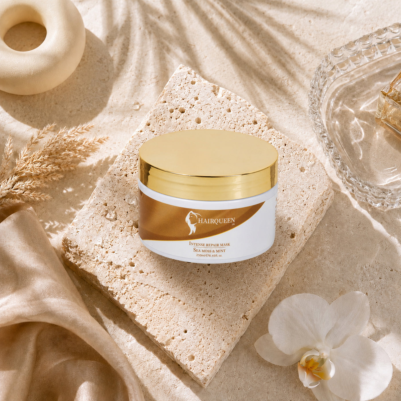 Hair repair mask jar with gold lid on a light stone pedestal
