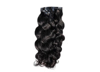 Black curly clip-in hair wefts with metal snap clips, seamless layered texture.