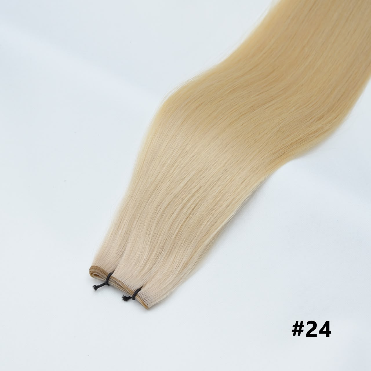 Tape-in hair extensions, straight strands in light blonde #24 with visible tape clips