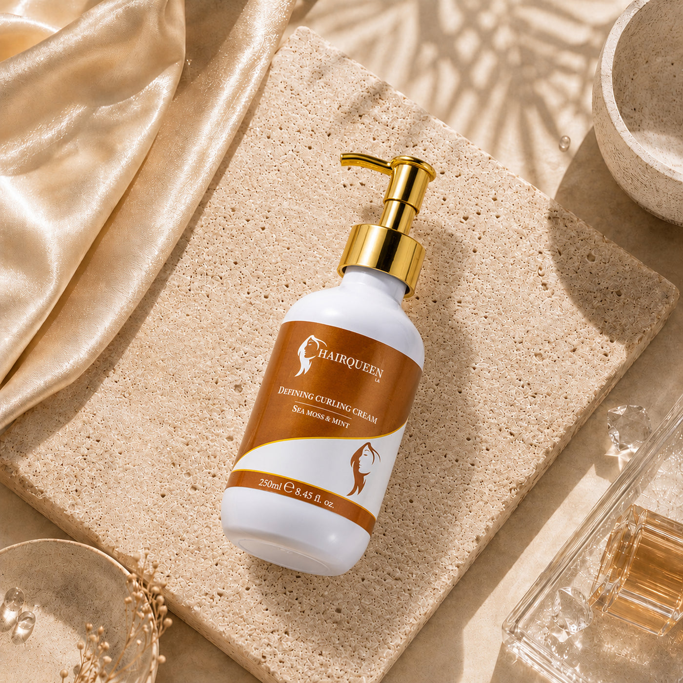 Curl cream bottle with gold pump on stone tile, white and orange label