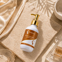 Curl cream bottle with gold pump on stone tile, white and orange label