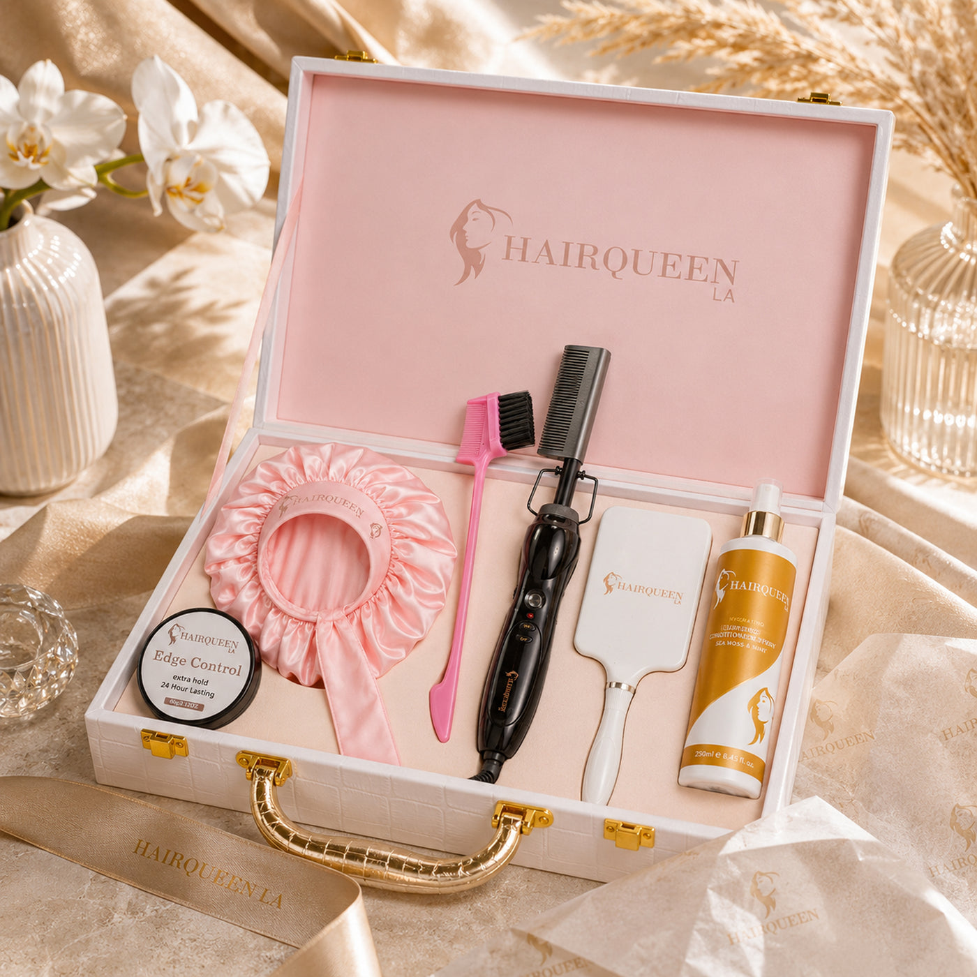 Hair extension kit gift set with pink satin bonnet, pink brush, black styling tool, and product bottles