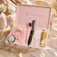 Hair extension kit gift set with pink satin bonnet, pink brush, black styling tool, and product bottles