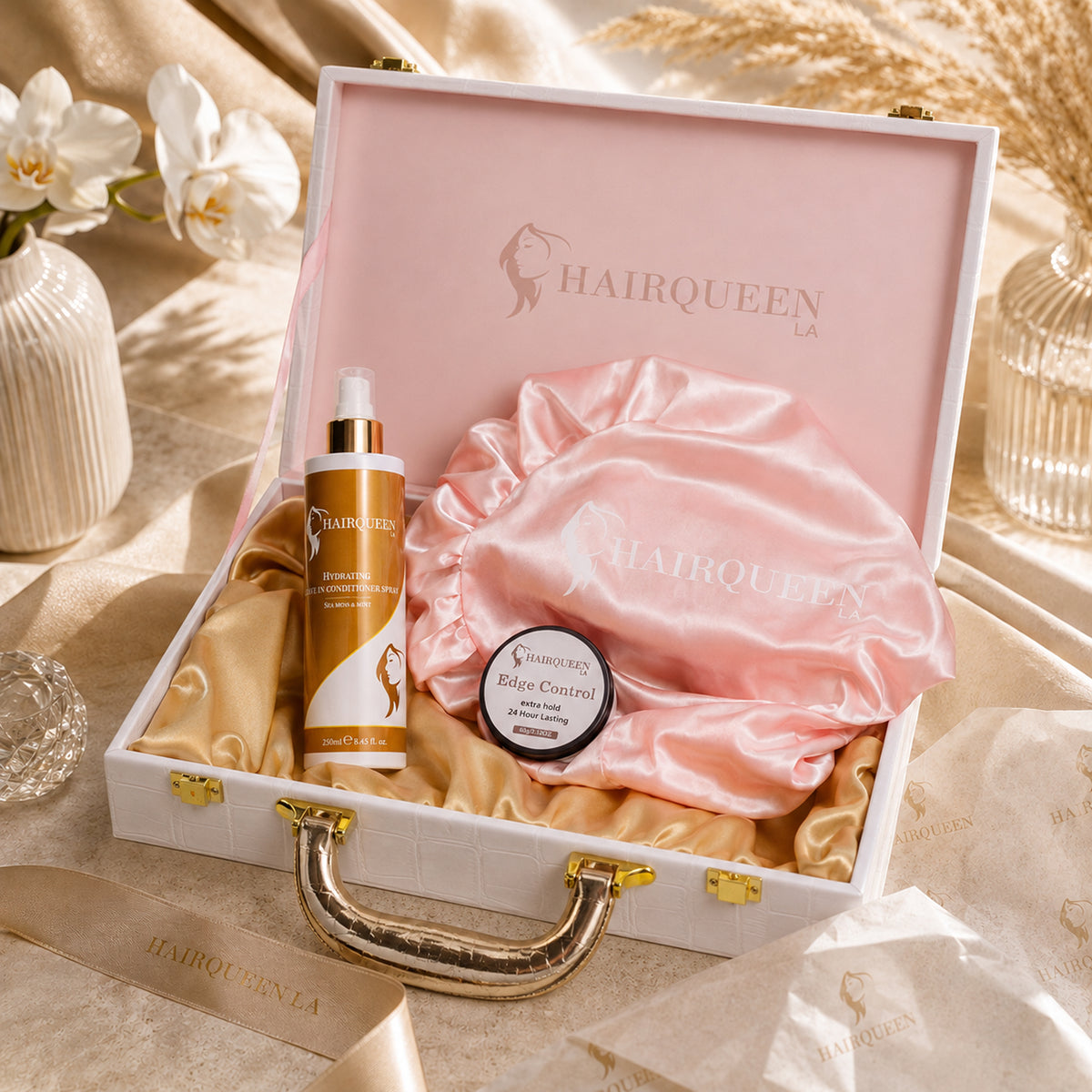 Hair care gift case with lid, pink bonnet, HAIRQUEEN spray bottle, and edge control jar