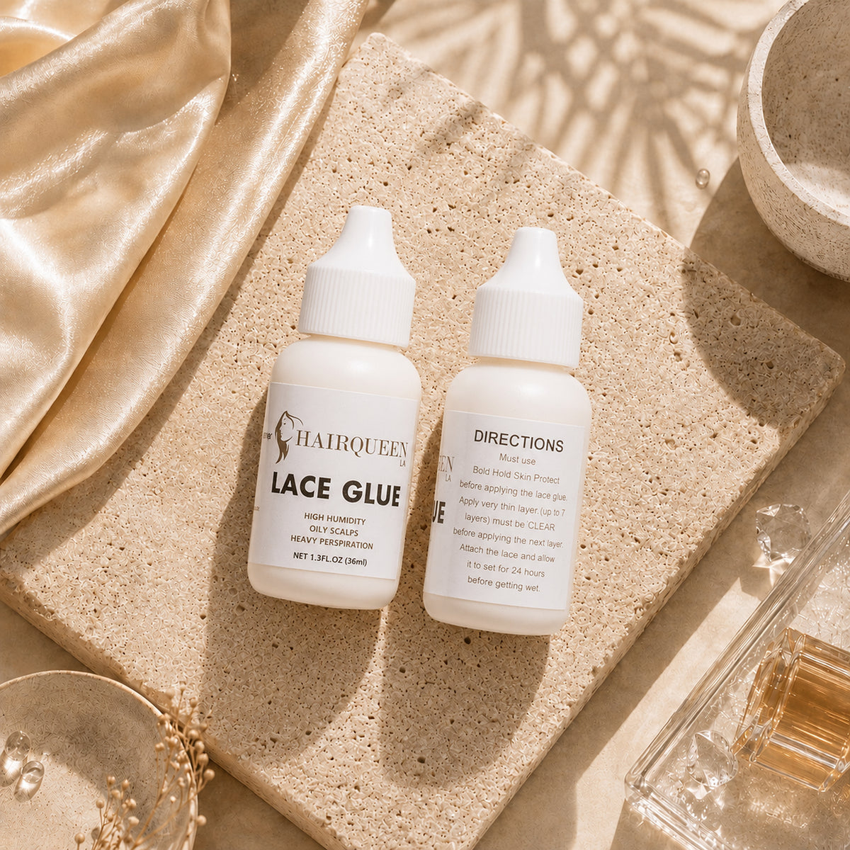 Hair Queen LA Lace Glue bottles on a speckled tray, two bottles side by side
