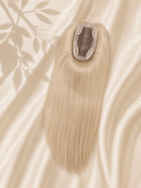 Clip-in mono base hair topper with long straight ash-blonde strands on beige cloth
