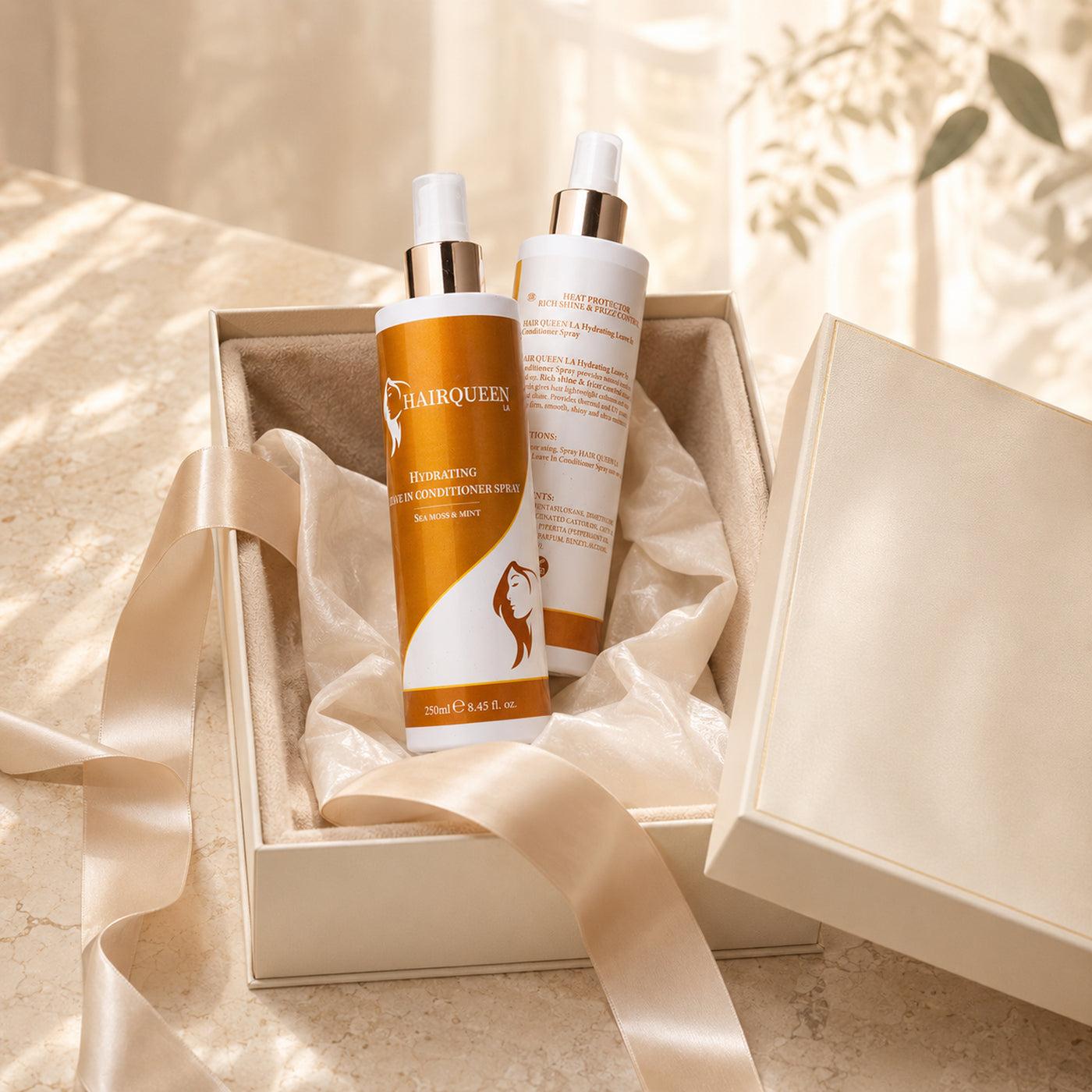 Hydrating leave-in conditioner spray bottles in an open gift box, orange labels, white caps