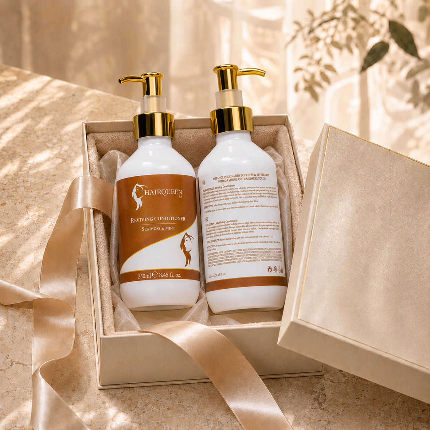 Two Hair Queen LA conditioner bottles in open box, gold pumps, white bottles with amber labels