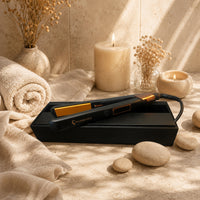 Black and gold hair straightener flat iron resting in a black storage case