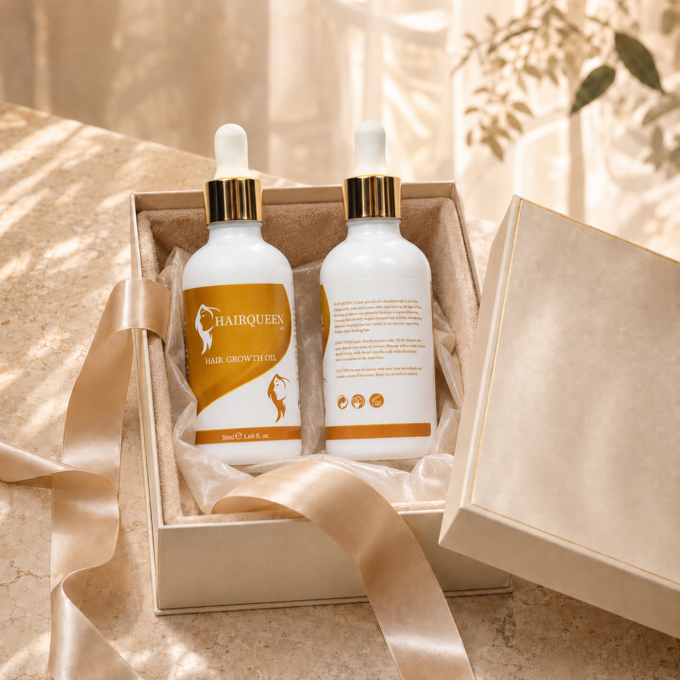 Hair Queen LA hair growth oil bottles in open gift box, white droppers and gold caps