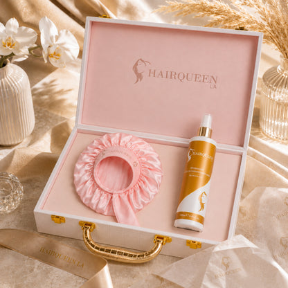 Open gift box with pink satin hair extension cap and amber conditioning spray bottle
