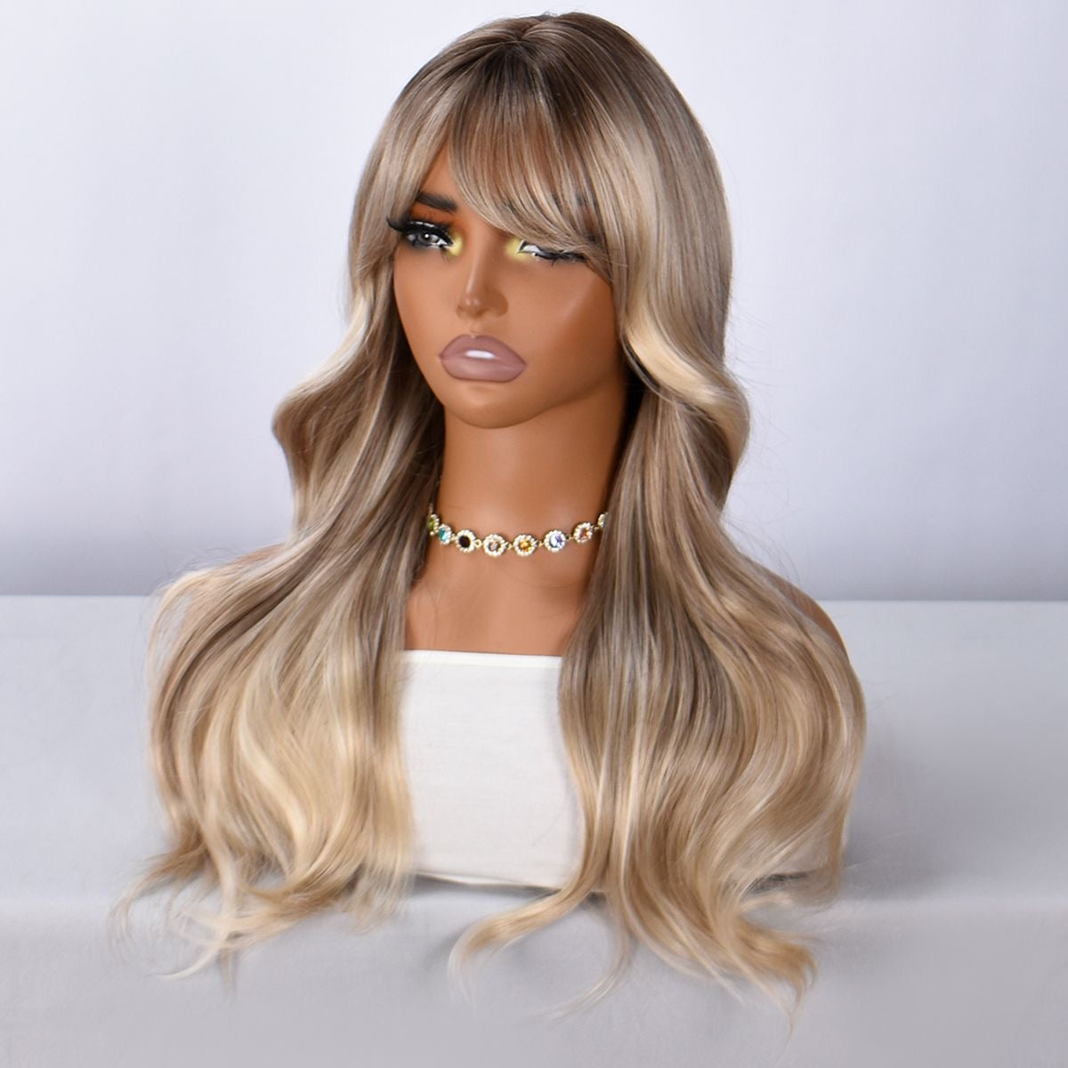 Long blonde ombre wavy synthetic wig with bangs, front angled view