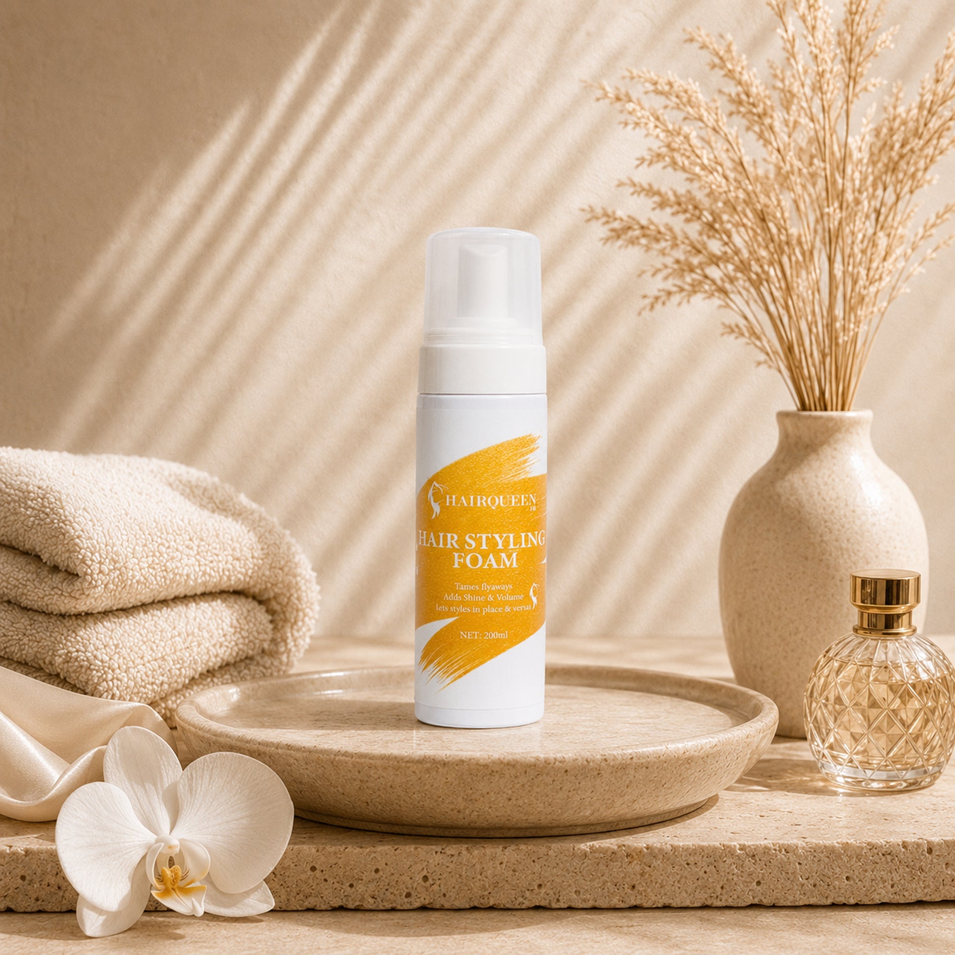 HQLA hair styling foam pump bottle on tray beside folded towel and orchid flower