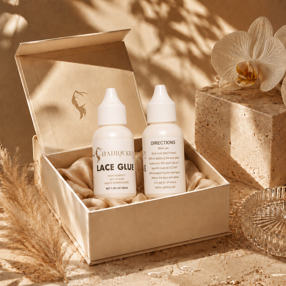Hair Queen LA Lace Glue set in an open box with two bottles and white orchid