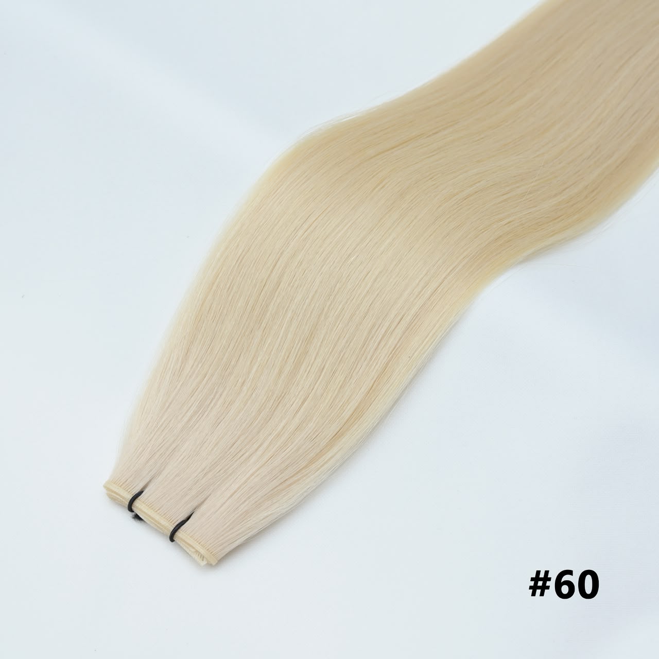 Tape-in hair extensions, straight strands in platinum blonde #60 with visible tape clips