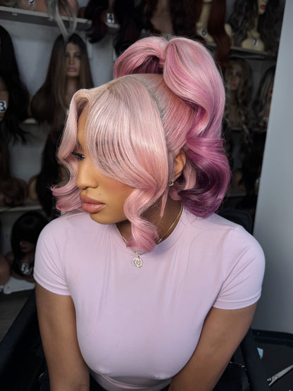 Two-tone rose pink and dark plum curly wig, side-parted with shoulder length hair