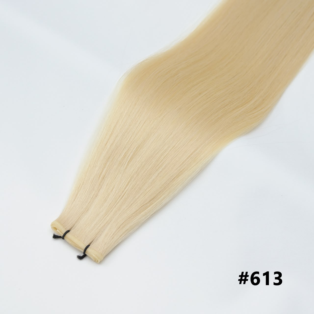 Tape-in hair extensions, straight strands in bleach blonde #613 with visible tape clips