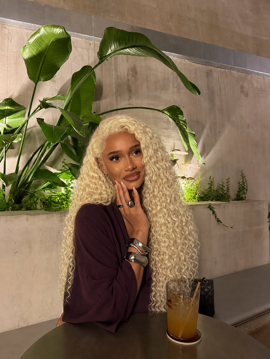 Human hair bundles in light blonde, long curly style on model