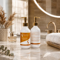 Pair of Hair Queen LA conditioner bottles with gold pumps, white bottles with amber and white labels