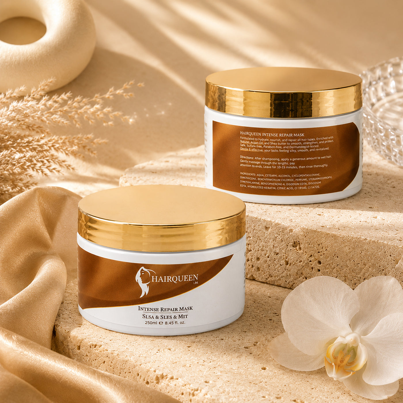 Hair repair mask jars with gold lids on a stone slab beside a white flower