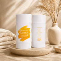 Two white HAIRQUREEN wax stick tubes standing on round stone tray