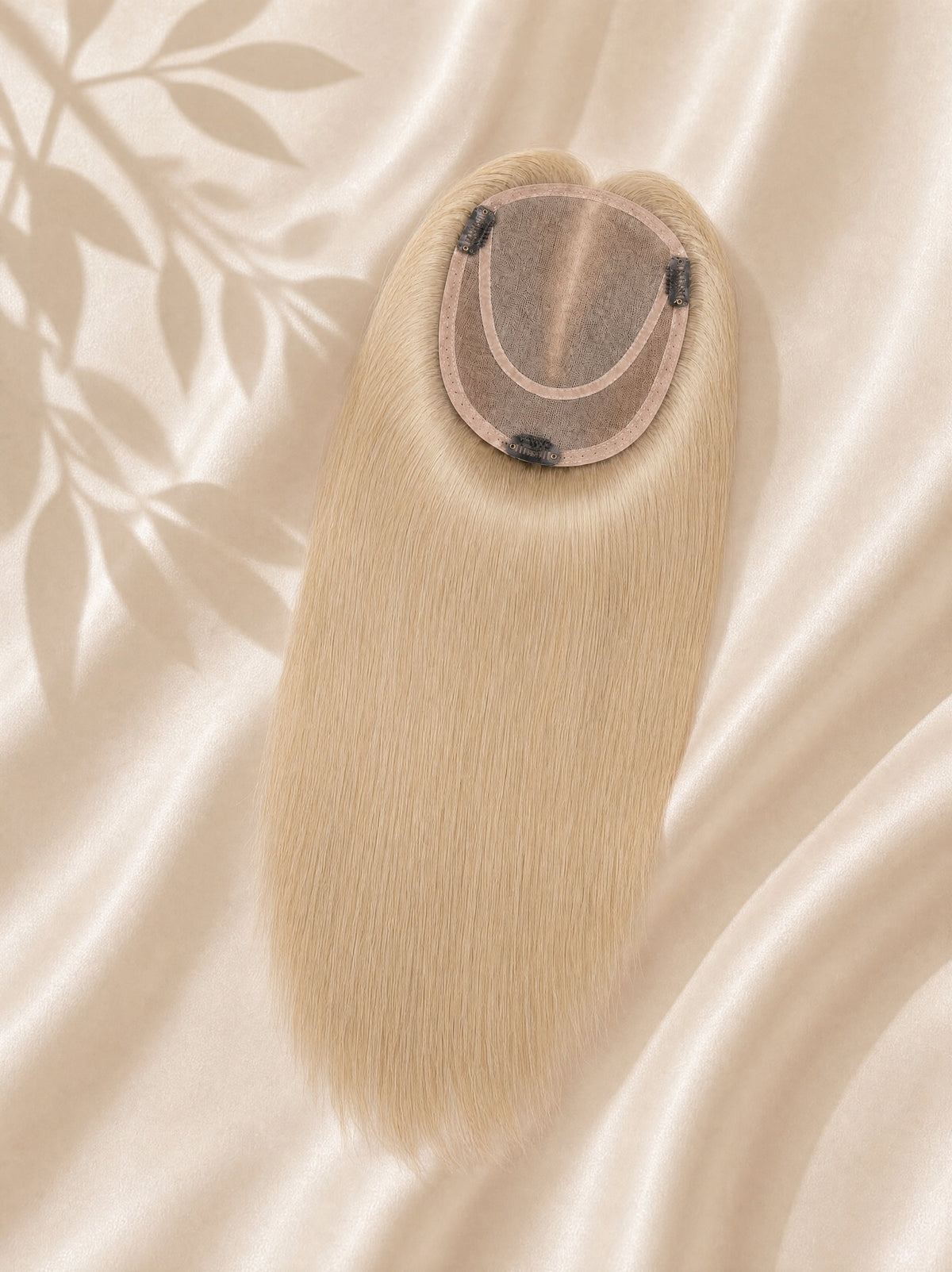 Light ash blonde mono hair topper close-up showing oval base and secure clips.
