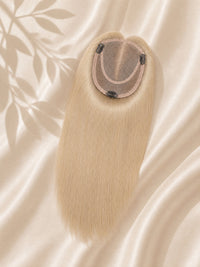 Light ash blonde mono hair topper close-up showing oval base and secure clips.