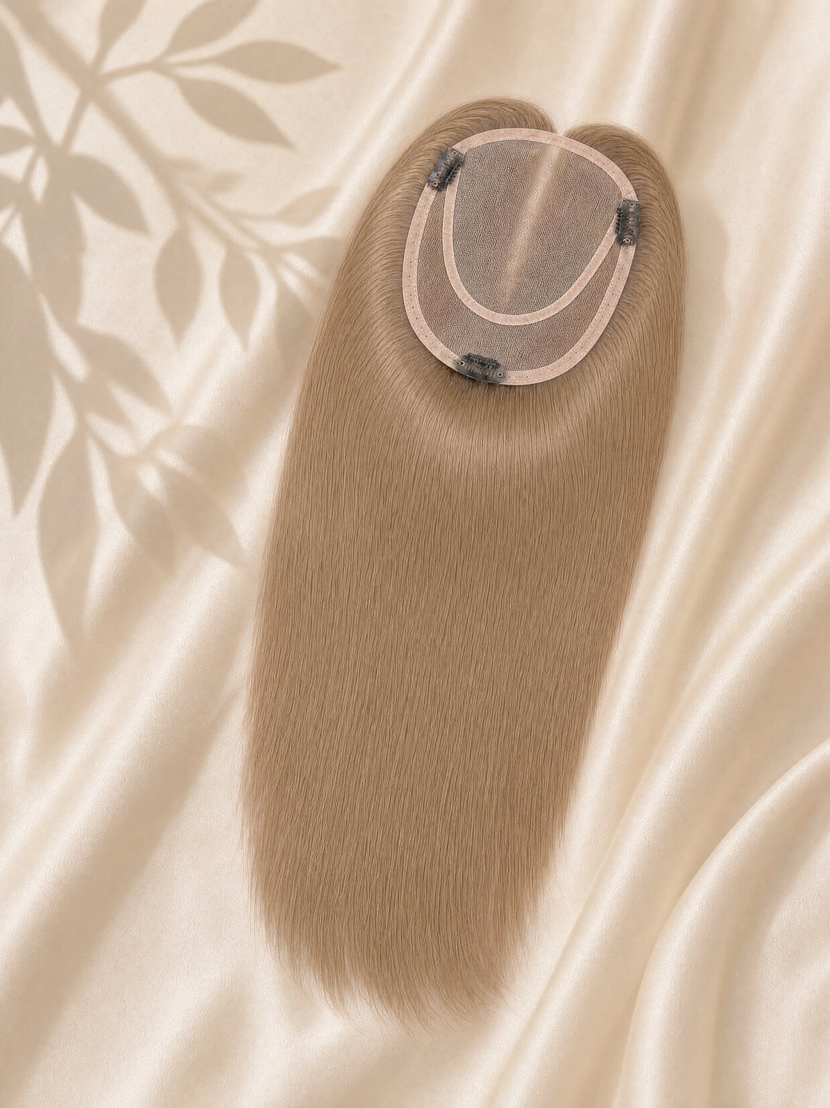 Light brown mono hair topper with round monofilament base, angled view