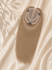 Light brown mono hair topper with round monofilament base, angled view
