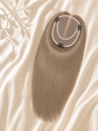 Light brown mono hair topper with round monofilament base on draped fabric