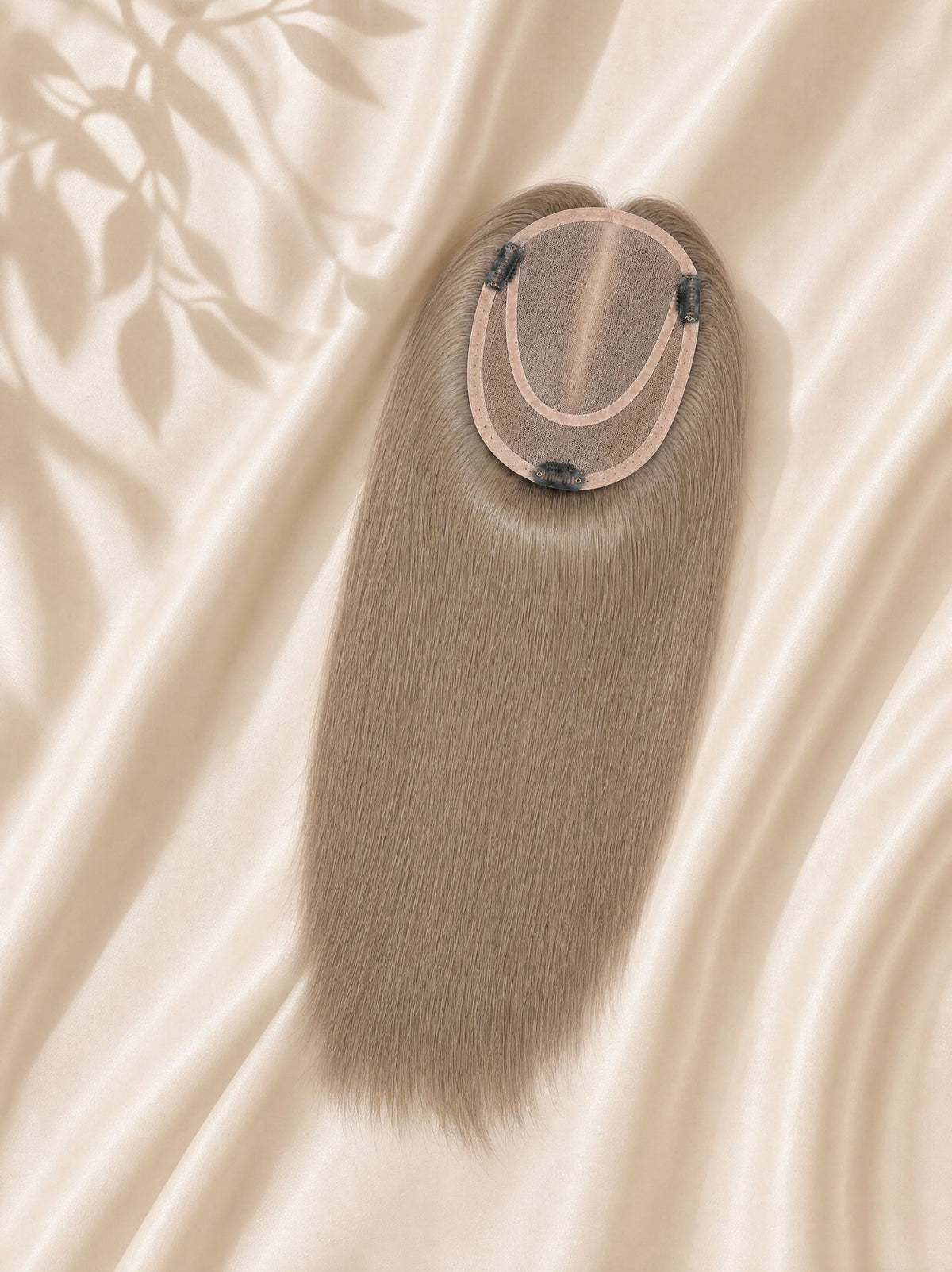 Close-up of light ash blonde mono base with clips and attached straight hair.
