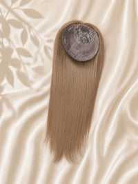 Light blonde hair topper showing round gray silk base cap and smooth straight strands