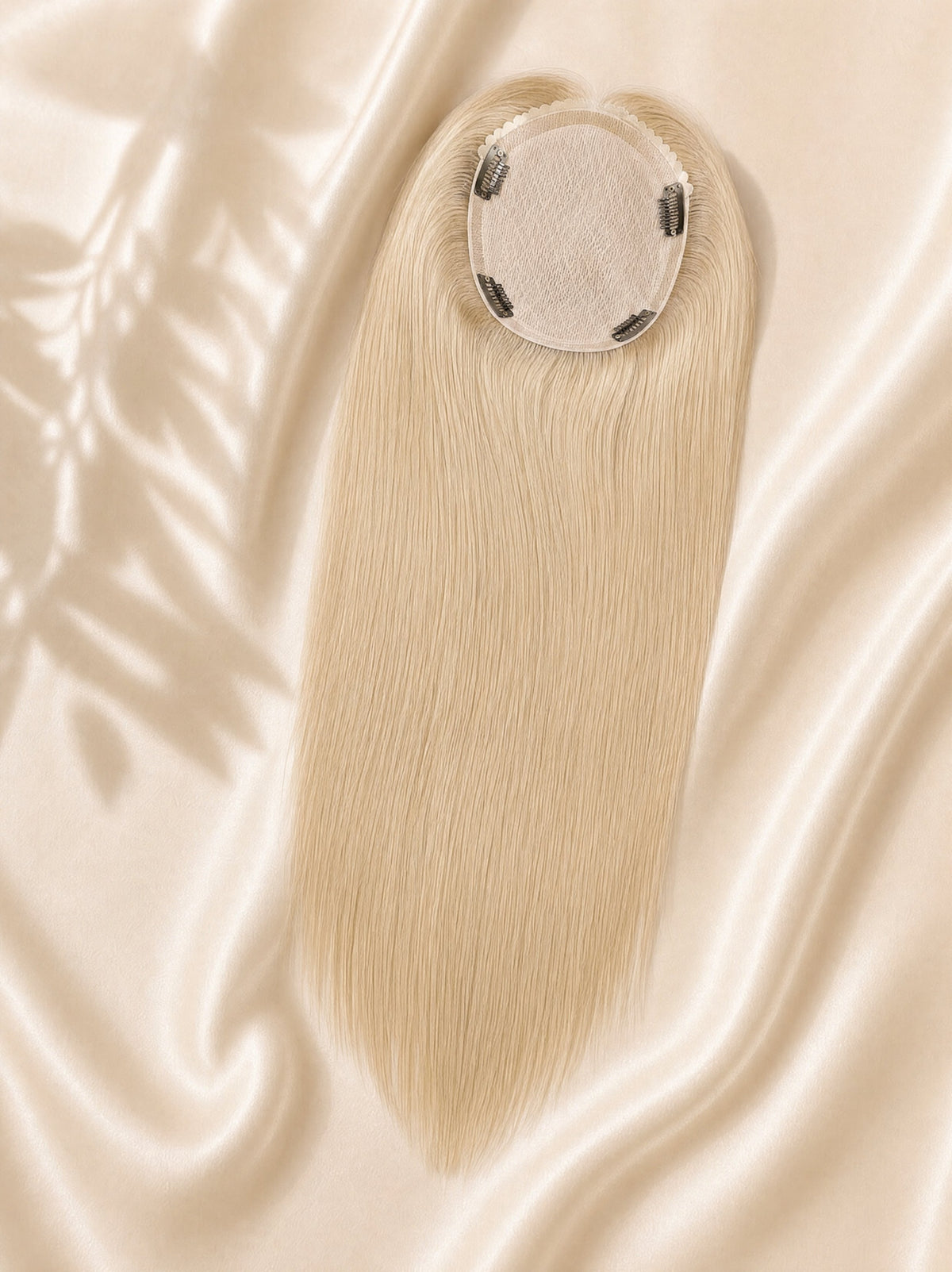 Light ash-blonde 6x7 silk skin hair topper with circular base and clips.