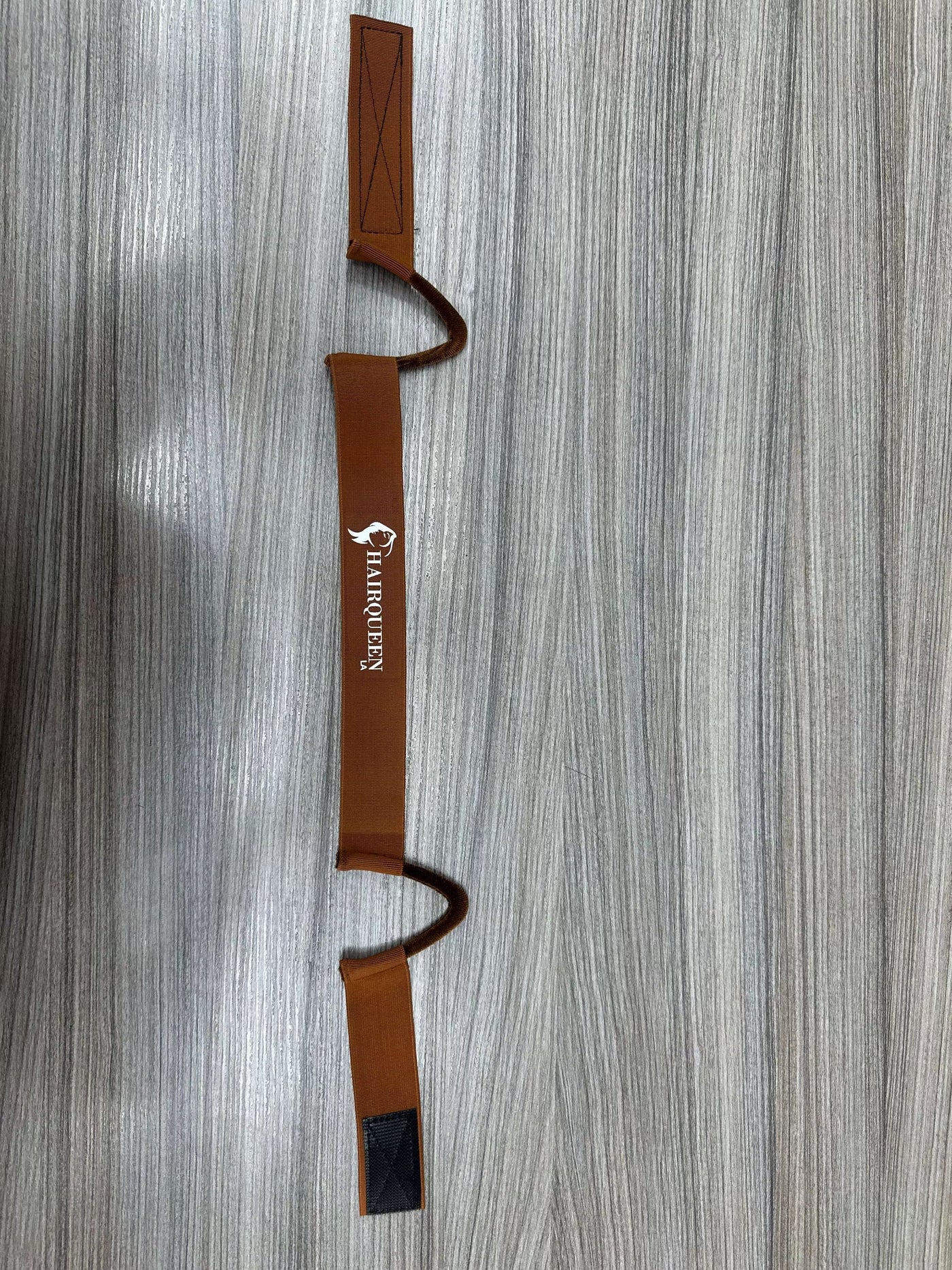 Brown wig band with HairQueen logo and end clips on a securing bar