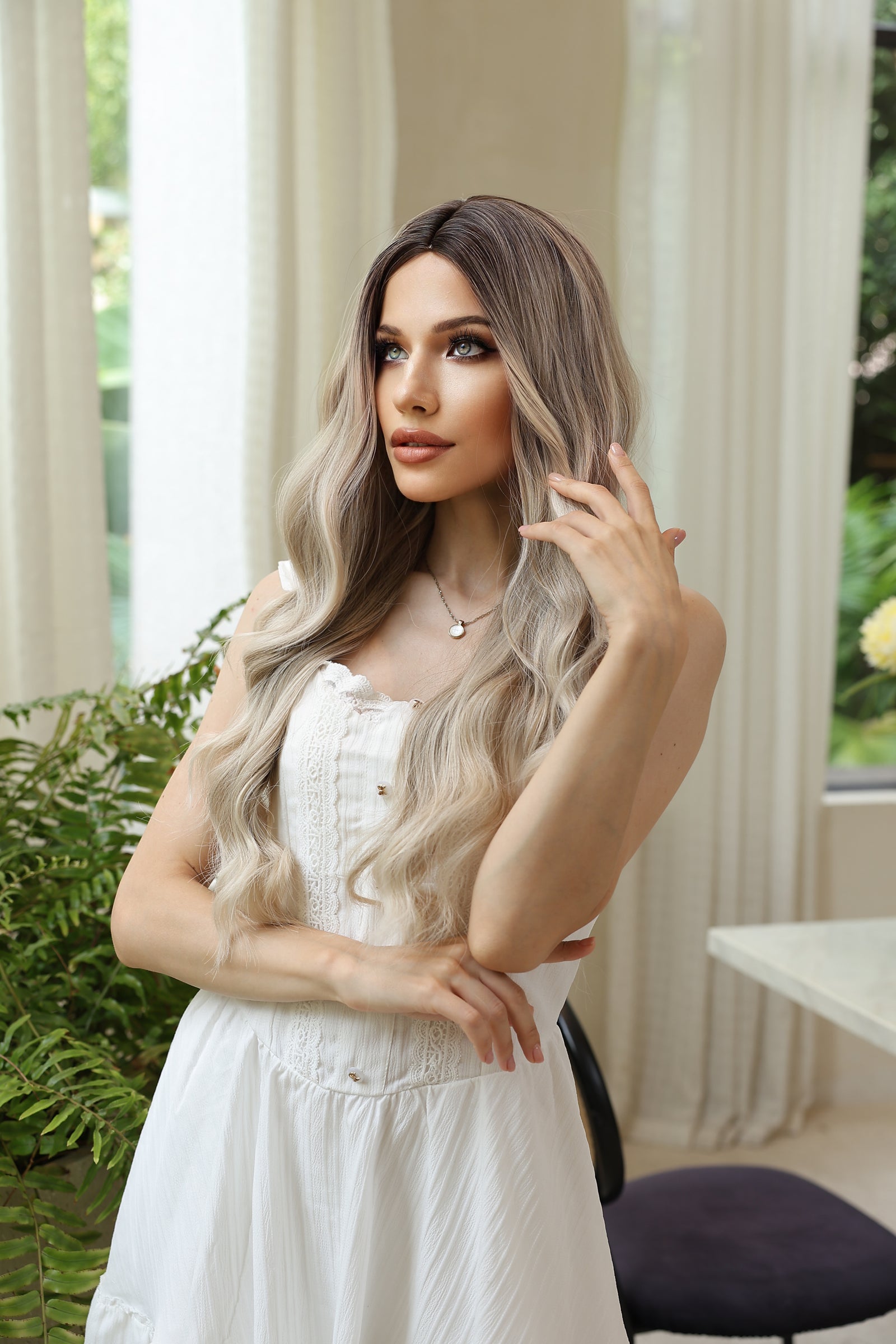 Long wavy blonde wig with dark roots, center part, face-framing highlights
