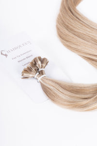 Blonde blend K-Tips hair extensions with visible tip bonds, long strands