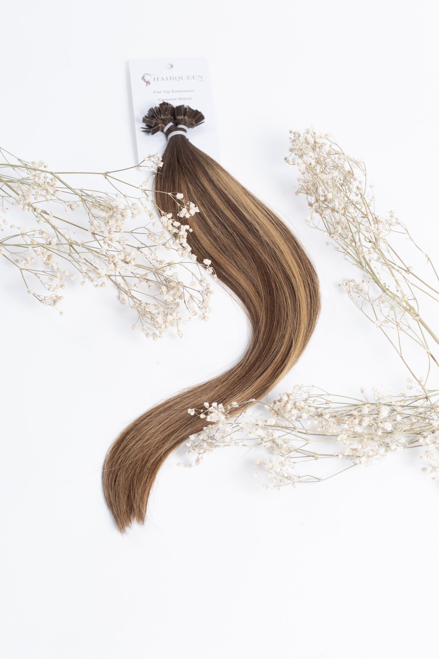 Caramel K-tips hair extensions, wavy strands tied with small dark clip bundle