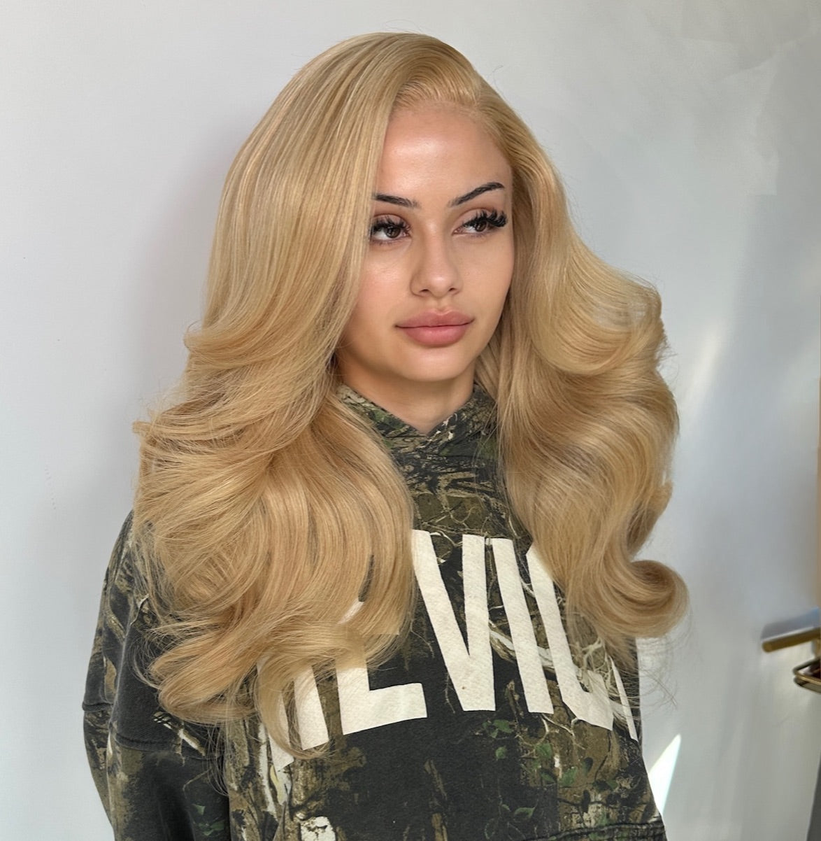 Long wavy blonde lace wig with deep side part, voluminous curls