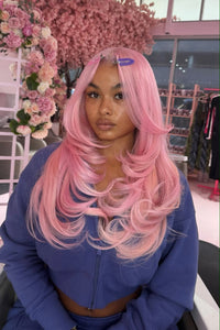 Long pink wavy wig with voluminous curls and side part