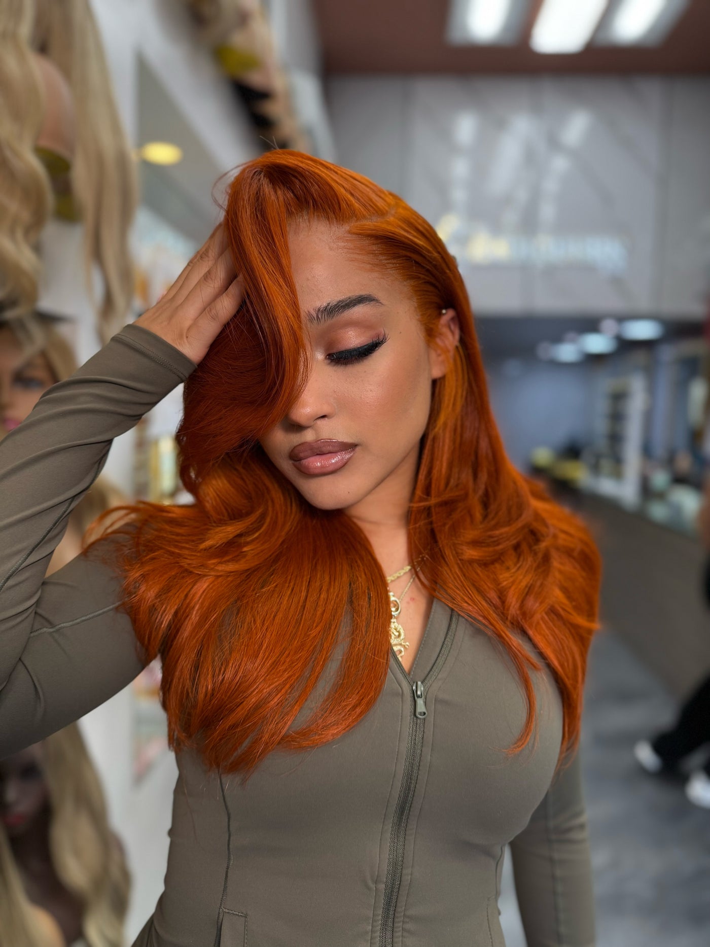 Long wavy ginger-orange lace wig with side part, full volume around crown