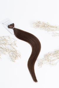 Chocolate brown tape-in hair extension strands with attached tape and card