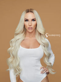Long wavy pale blonde wig with center part, loose curls over shoulders