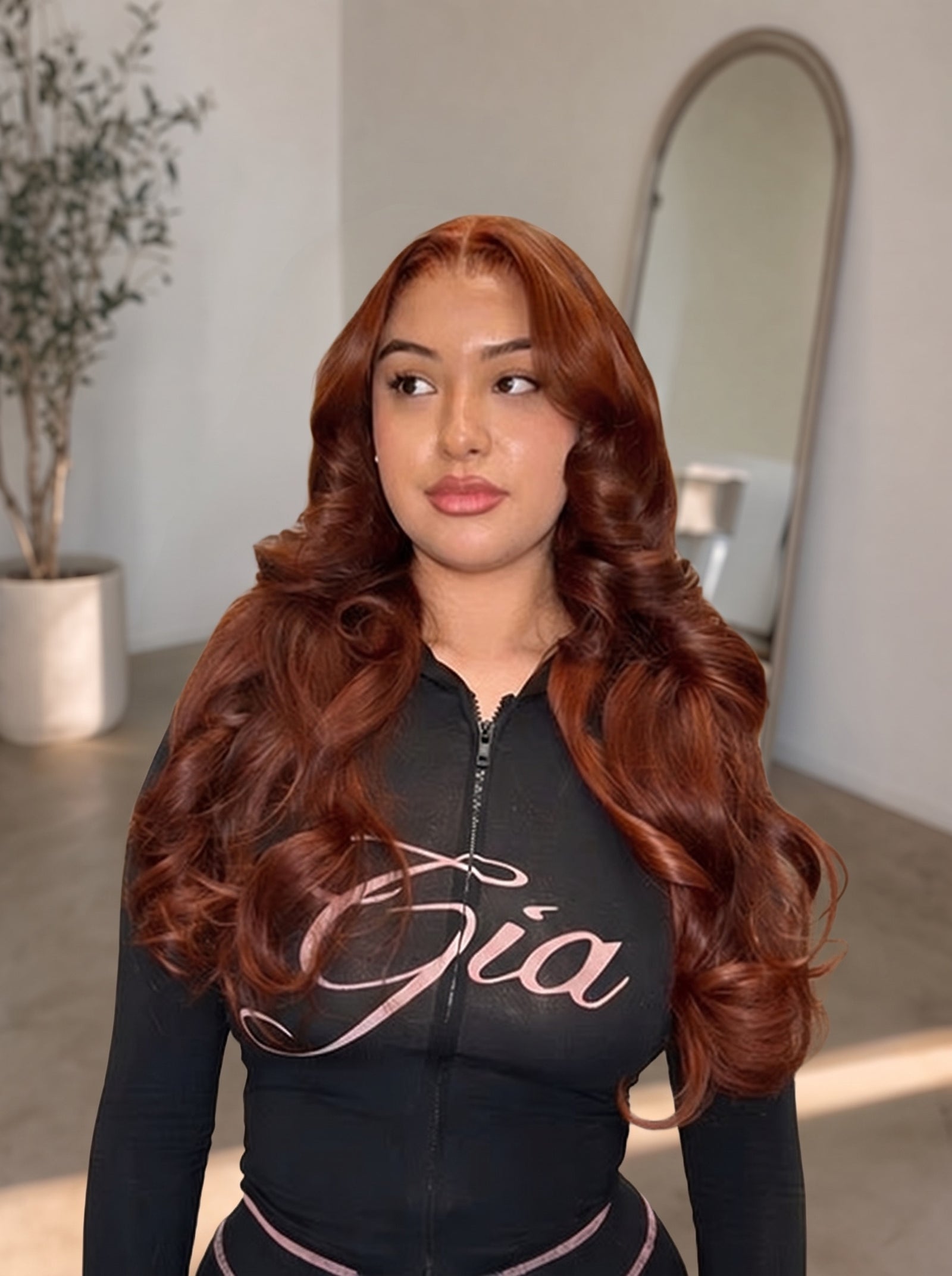 Auburn long wavy lace wig on model wearing black zip hoodie