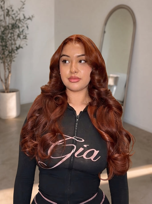 Auburn long wavy lace wig on model wearing black zip hoodie